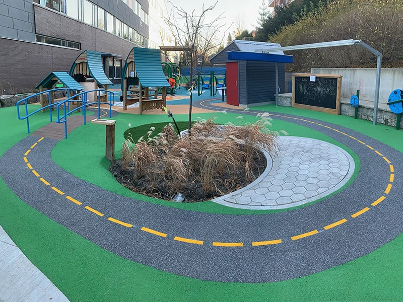 Colorful playground with safety surfaces and play structures.
